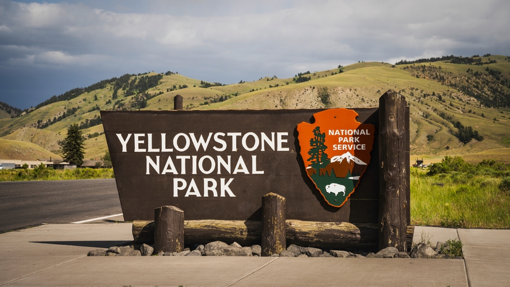 Gardiner, Montana USA - June 26th, 2024: Yellowstone National Park South Entrance Sign in front of the Roosevelt Arch at the north entrance to Yellowstone National Park.
