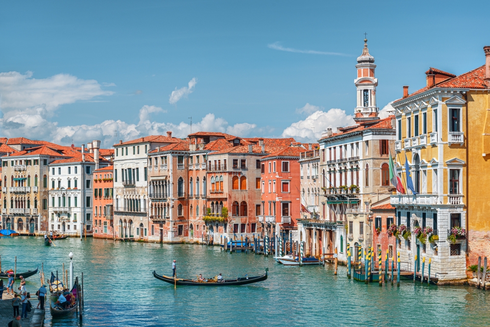 Beautiful view of the Grand Canal with boats and colorful facades of old medieval houses from the Rialto Bridge in Venice, Italy. Venice is a popular tourist destination of Europe.