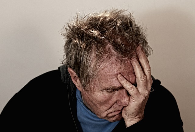 man holding head in agony