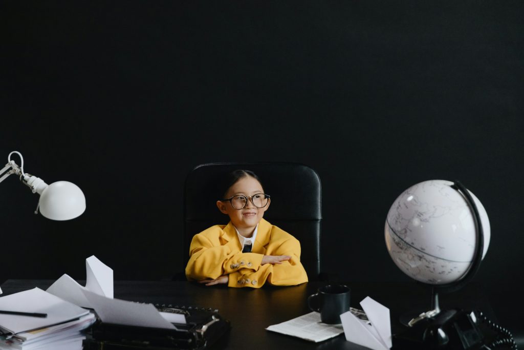 Asian girl in yellow suit sitting on chair and looking away