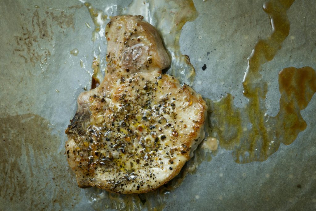 pork chop in skillet with a lot of grease