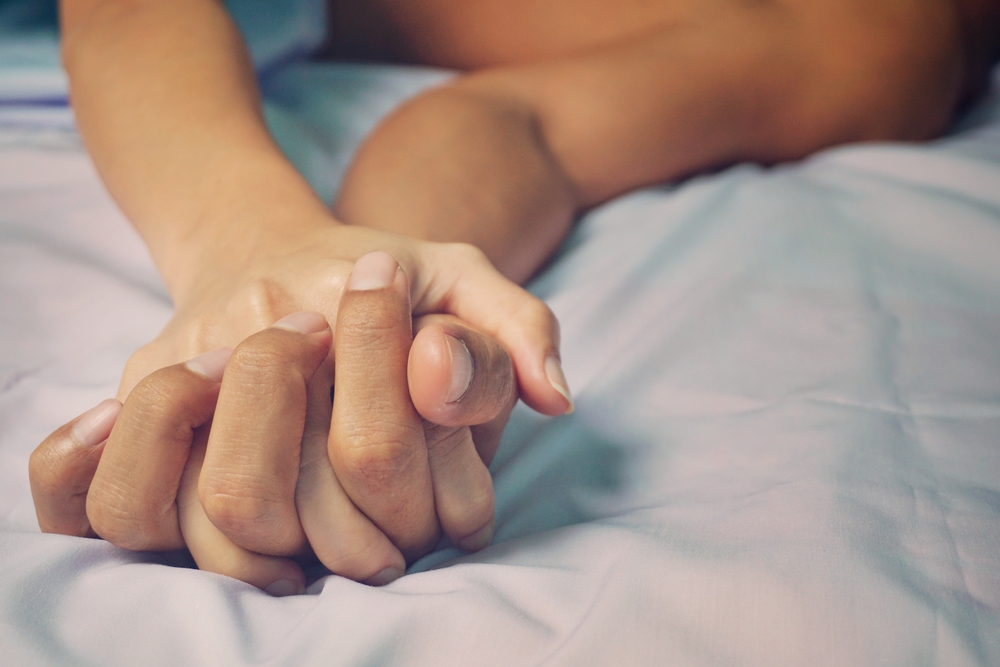 man and woman hands having sex on a bed. make love.