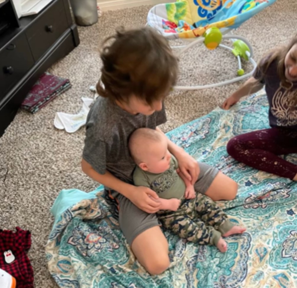 family sitting on blanket with baby
