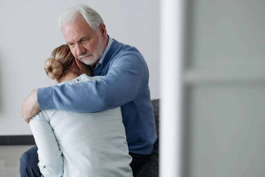 Elderly man hugging younger woman