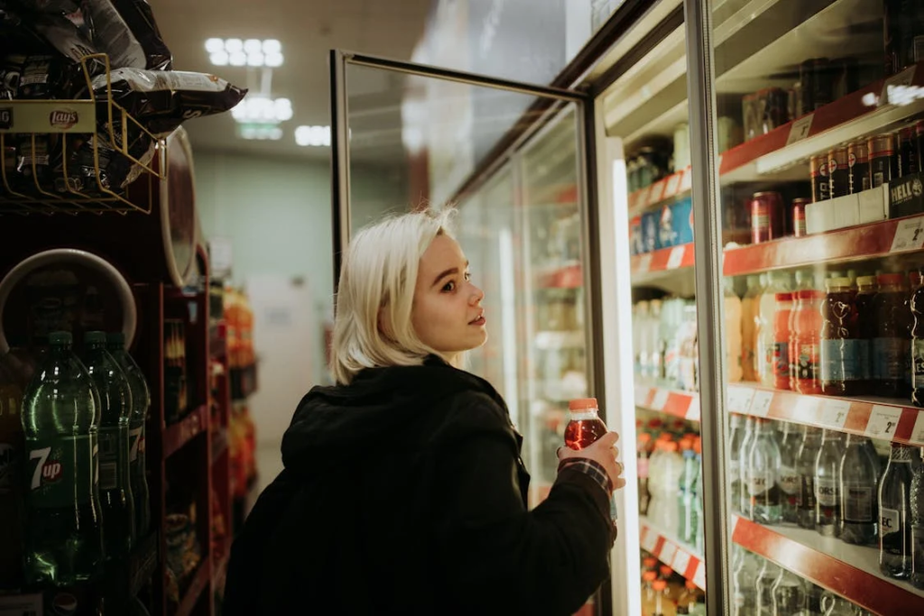 Woman Buying a Drink from a corner shop