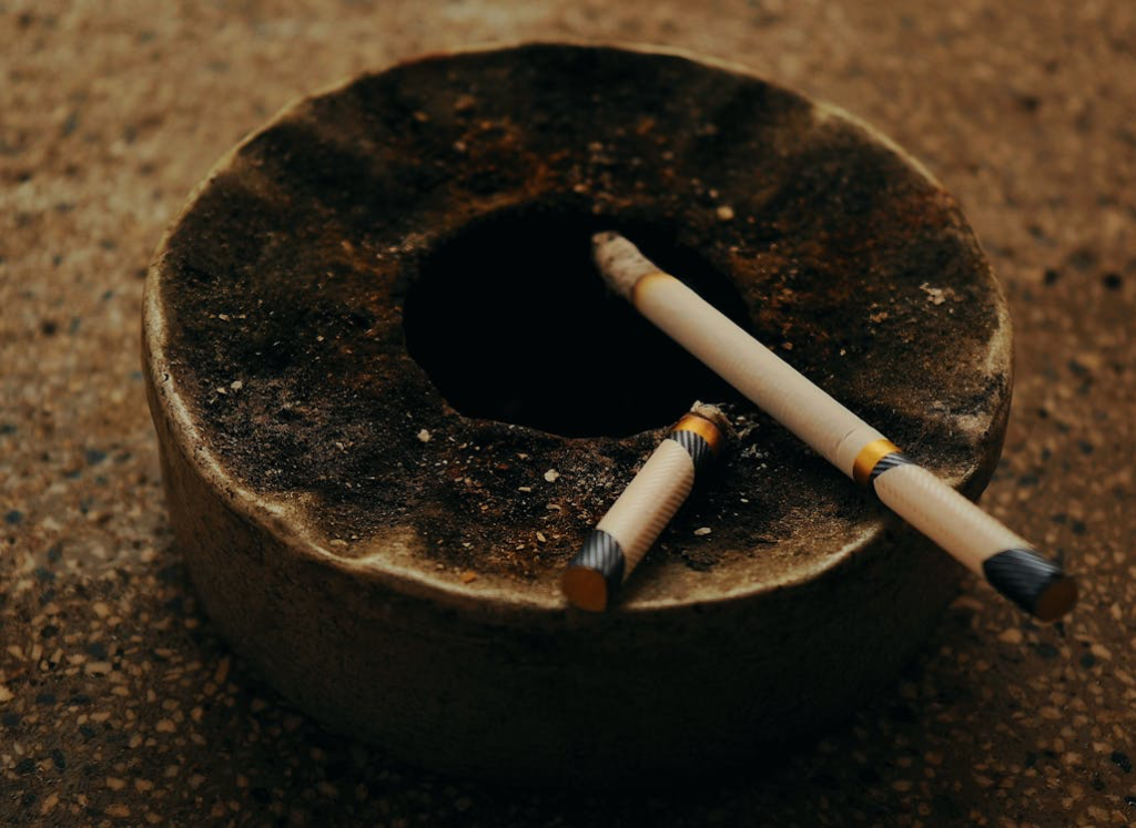 Close-up of an ashtray with cigarette butts, illustrating smoking cessation support available through Medicare benefits, which includes counseling sessions to help beneficiaries quit.