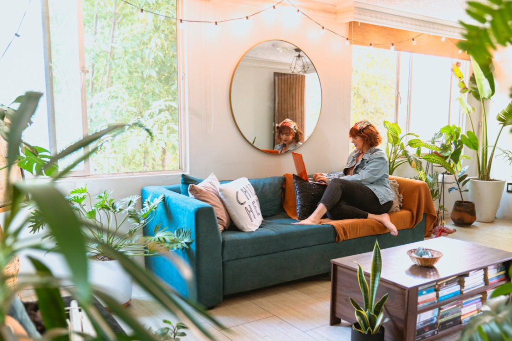 Woman Using Her Laptop in lounge filled with houseplants