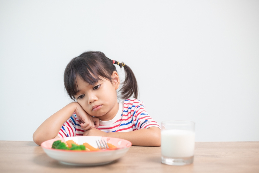 Nutrition healthy eating habits for kids concept. Children do not like to eat vegetables. Little cute girl refuses to eat healthy vegetables.