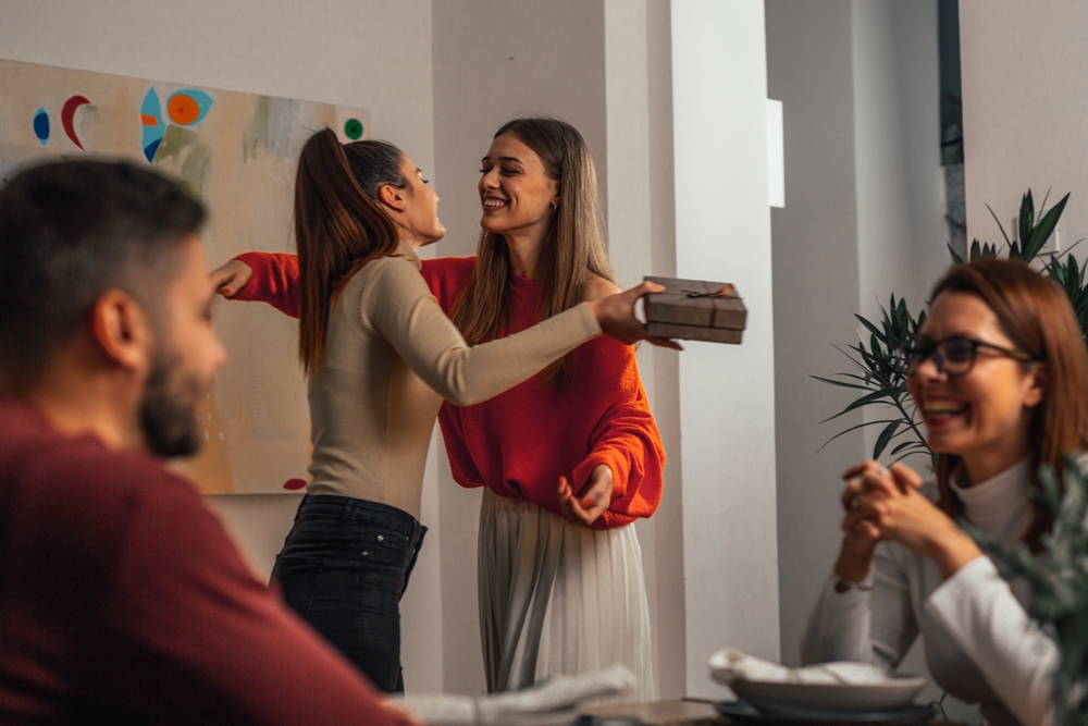woman embracing friend during family gathering at dinner party