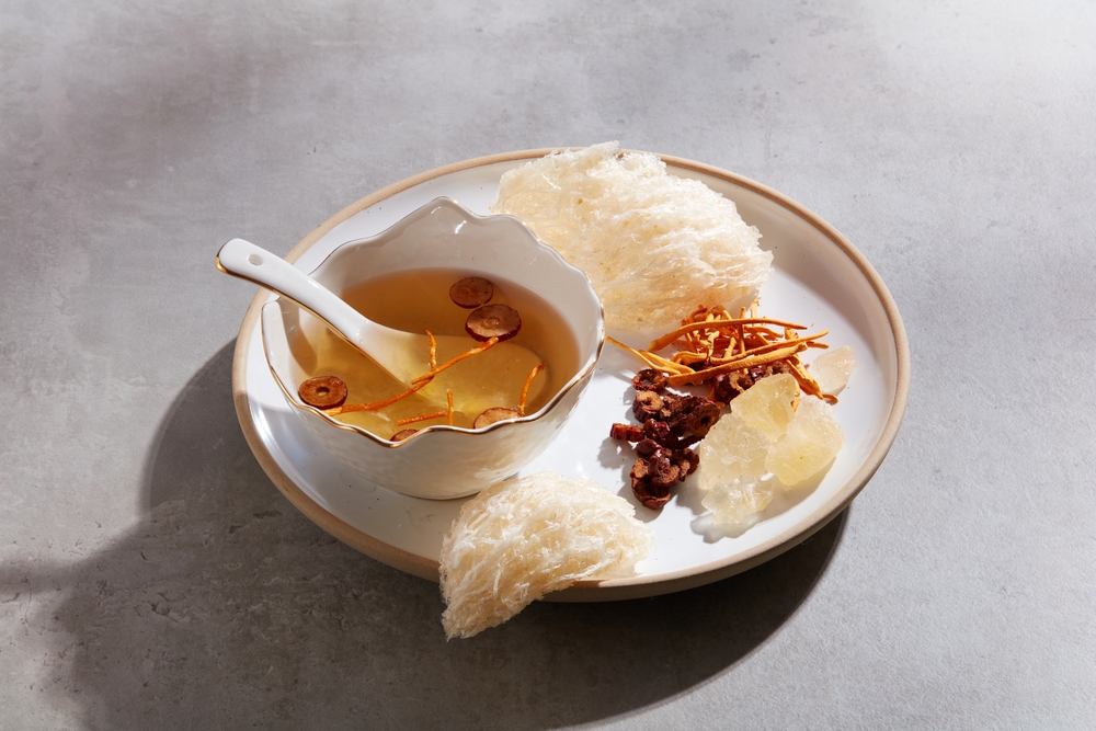 Edible bird’s nest displayed with a bowl of bird’s nest soup with jujube and cordyceps and rock sugar on a ceramic dish. A luxury combination for healthcare