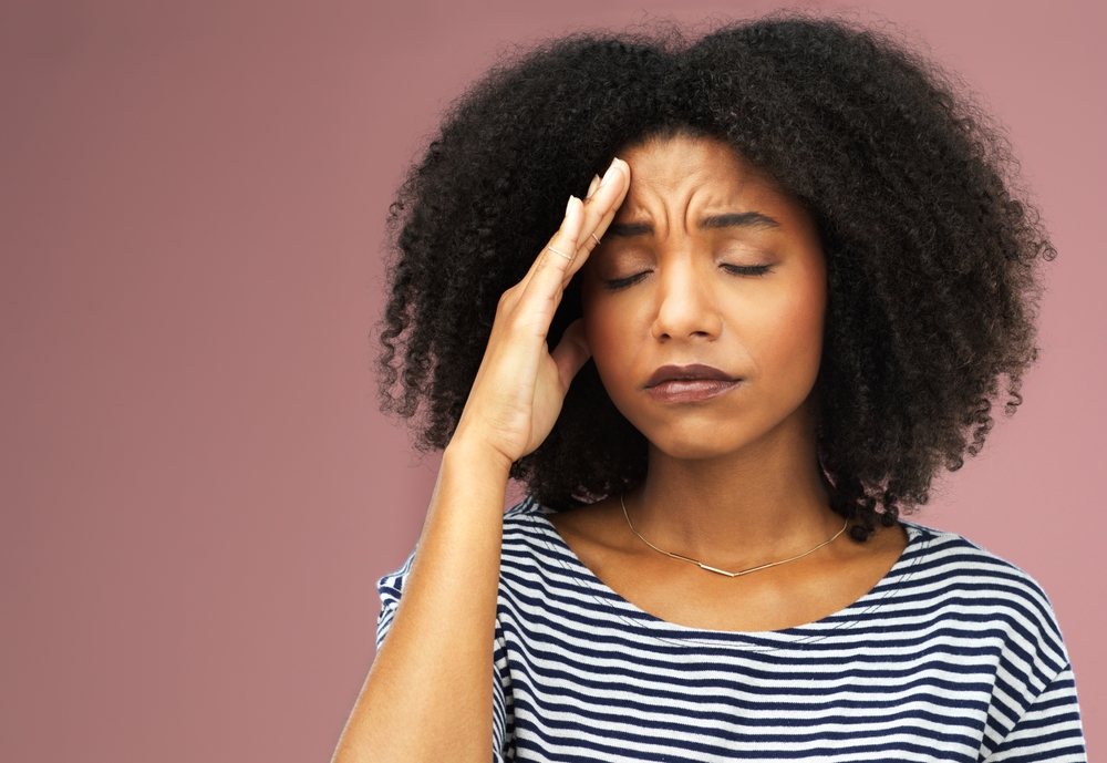 Black woman, pink background or headache with pain, tired from stress or anxiety. Female person, burnout or mental health in studio with tension migraine, hand for relief with mockup in New York City