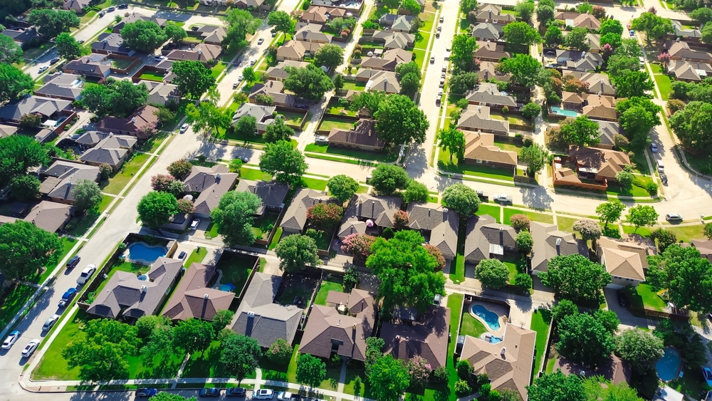 Large two-story suburban houses with swimming pool in upscale residential neighborhood North of Dallas, Texas, lush greenery area of Coppell, DFW Fort Worth metroplex urban sprawl, aerial view. USA
