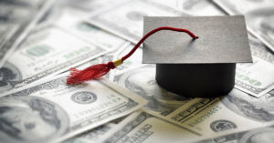 graduation hat placed on various American tender. Student loan concept