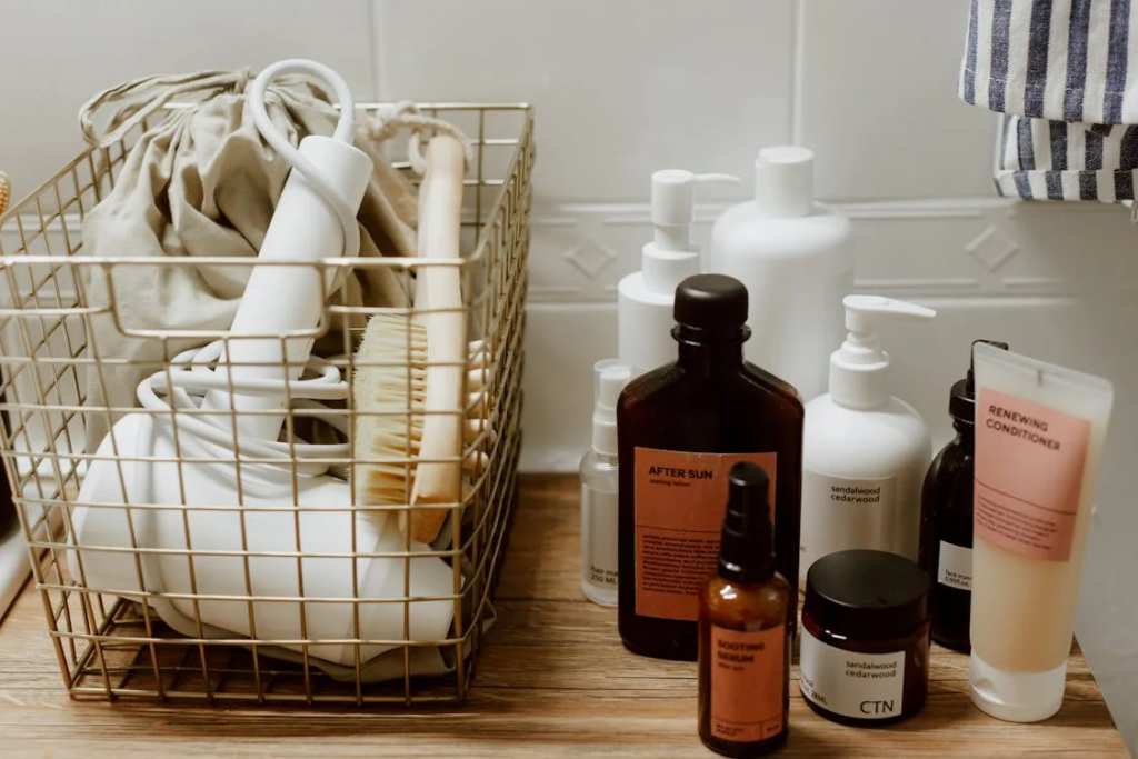 Bathroom products including bottles of shampoo, conditioner, and after-sun lotion arranged next to a gold wire basket containing a hair brush & hair drying, showing items that don't belong in a closet.