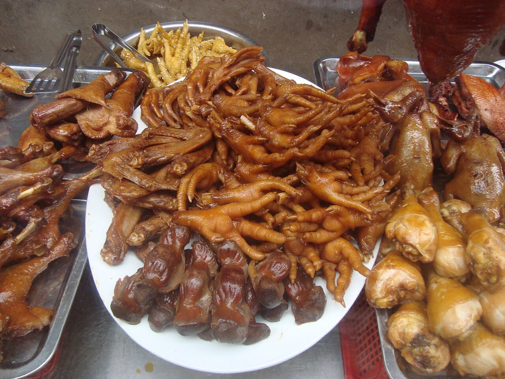 Chicken feet and other chicken parts ready for sale on a roadside cart in Haikou, Hainan, China.