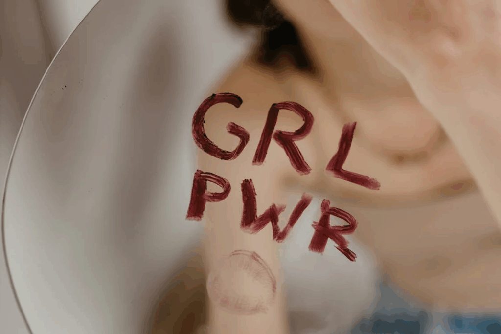 Close-Up Shot of a Mirror with 'grl pwr' written in lipstick