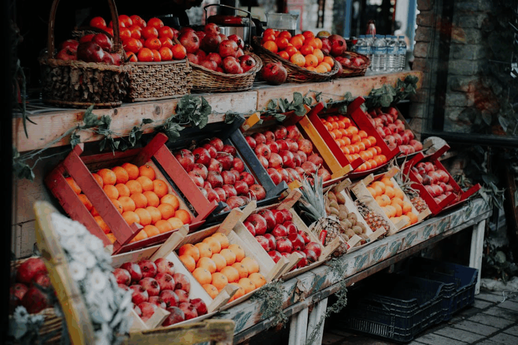 Vibrant display of apples and other fruits in wooden crates at a market stall, showing fresh produce that has seen varied price changes across different regions.