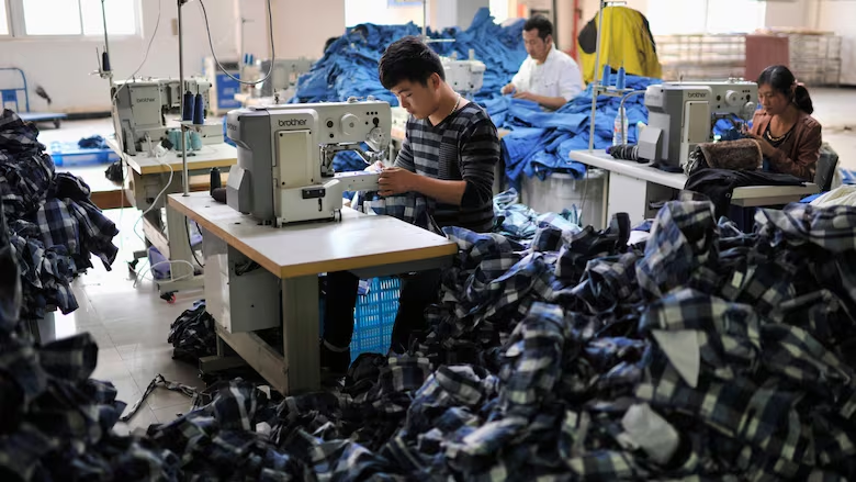 Employees work inside a factory manufacturing clothes for export in Wuhu, China, in 2013