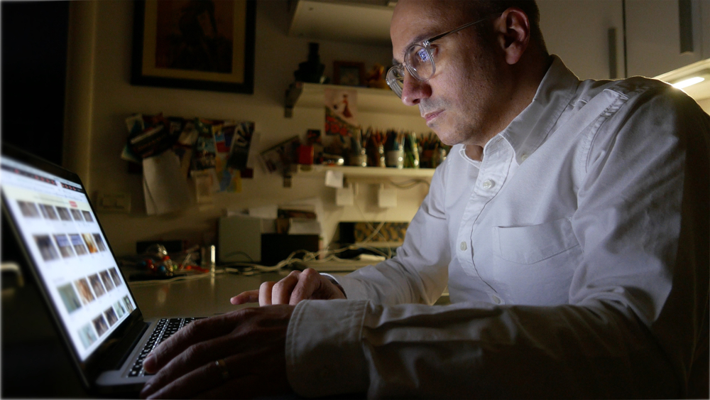 Man surfing the web with laptop at home during night time.