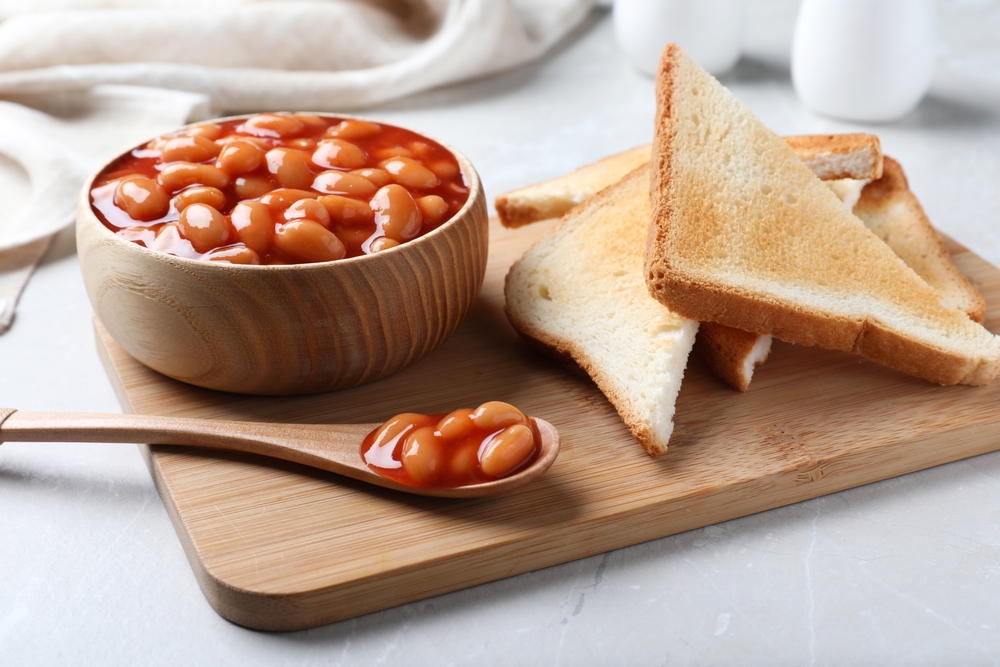 Toasts and delicious canned beans on white table