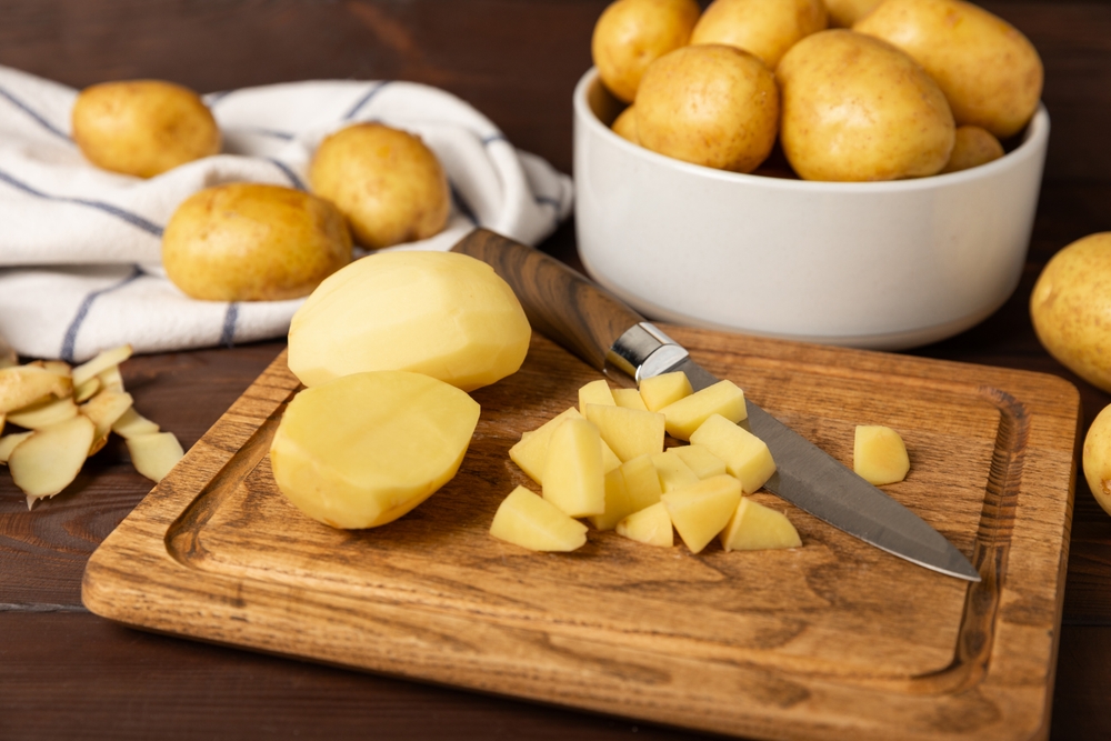 Young potatoes. Raw potatoes and knife on a wooden background.Peel potatoes.Harvesting collection. organic, freshly dug potatoes. Agricultural background. Vegan. Vegetables.Place for text.Copy space