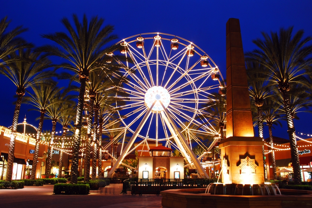 Irvine, CA, USA March 25, 2013 A Ferris wheel, palm trees and the surrounding buildings are illuminated at night at the Spectrum, an outdoor shopping mall in Irvine California
