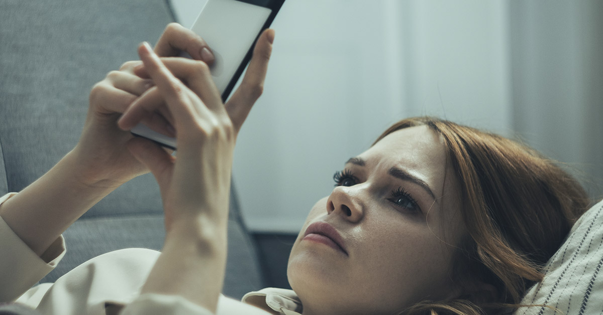 Woman using her smartphone browsing social media. Doomscrolling concept