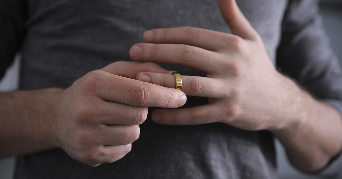 person taking off wedding ring or band. Cheating, infidelity concept