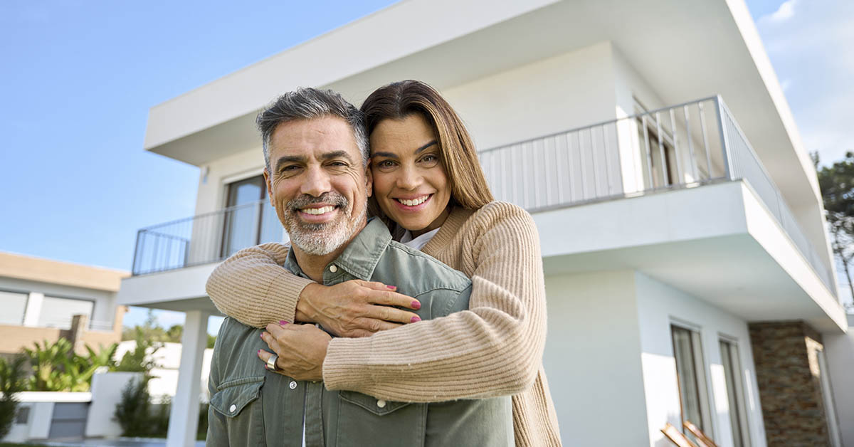 couple , a man and woman, standing in front of their home