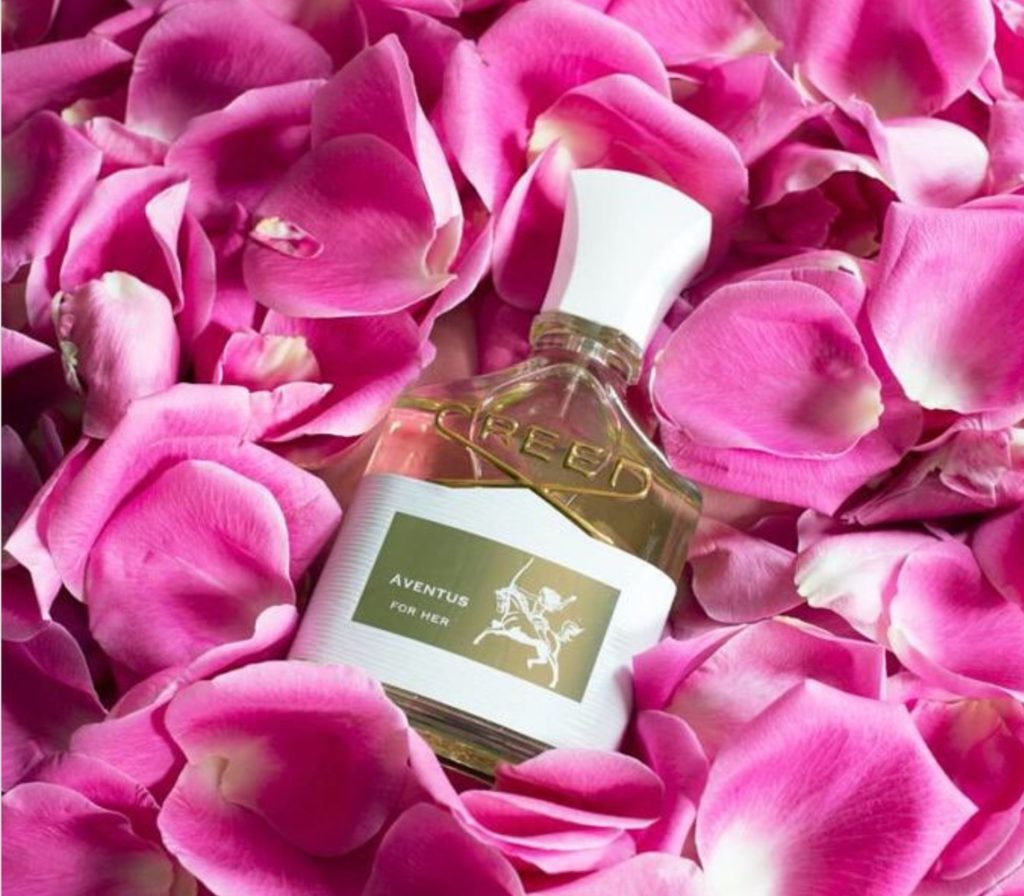 Bottle of perfume with rose petals