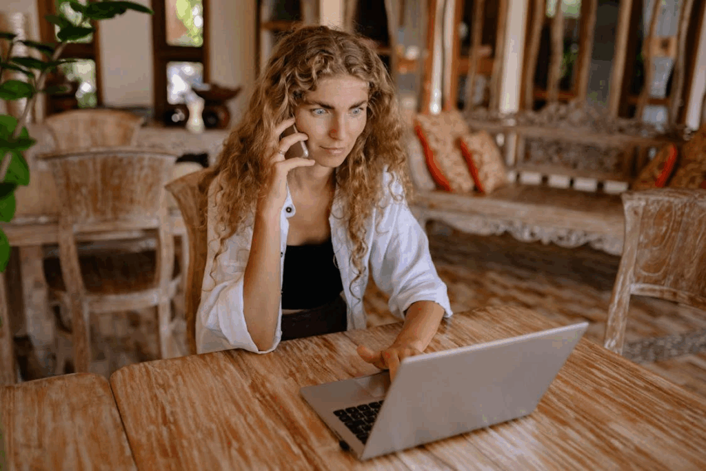 Photo of Woman Using Smartphone and Silver Laptop