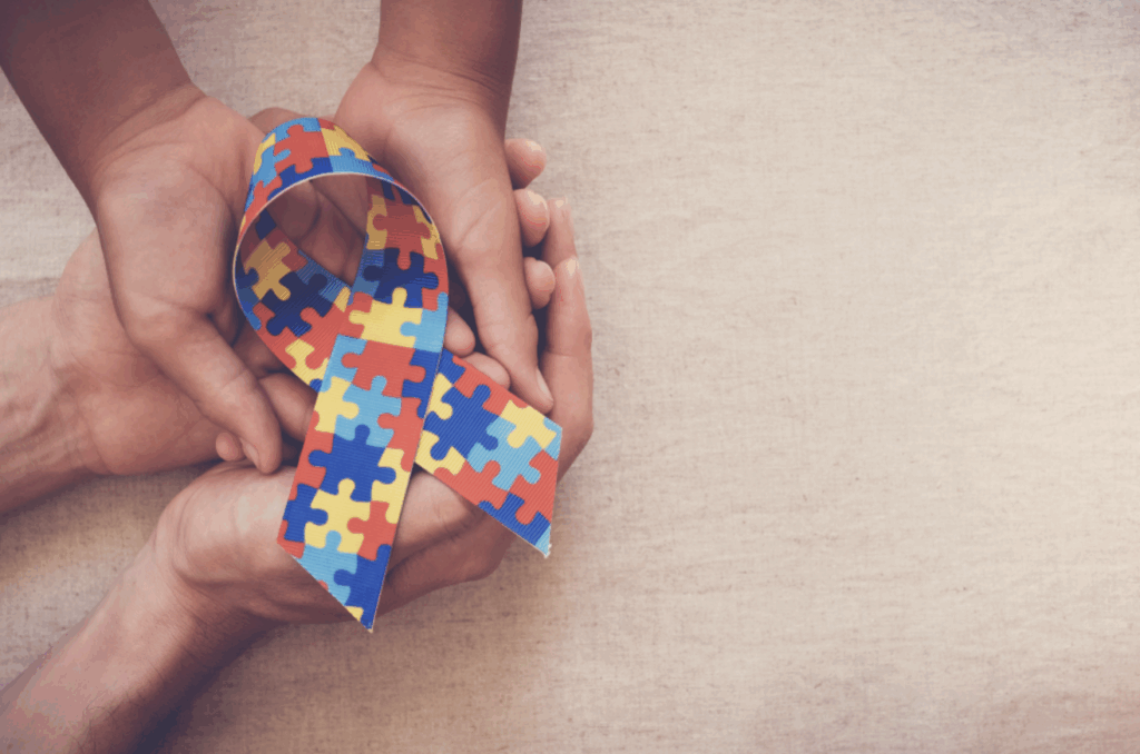Hands holding puzzle ribbon for World Autism spectrum disorder Awareness Day, pride, jigsaw