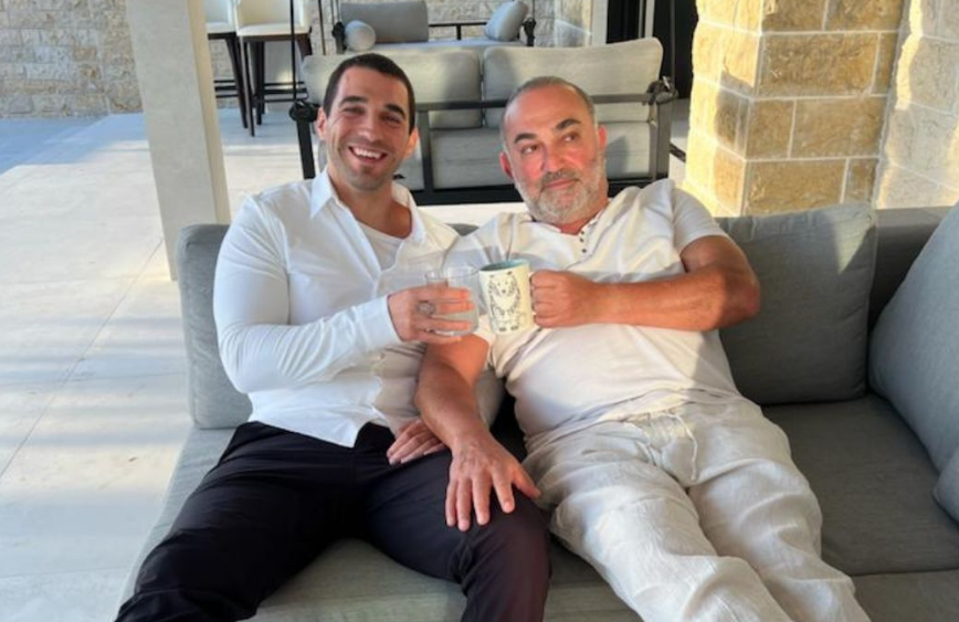 Adam with his father on a couch