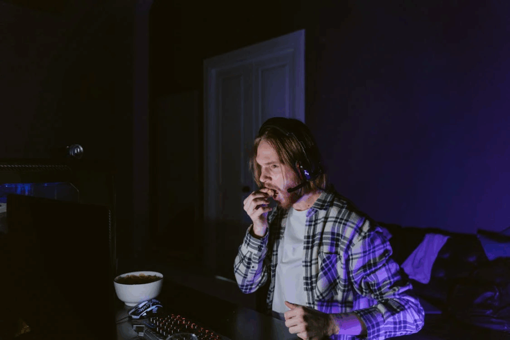 A Man Sitting in Front of a Computer Eating