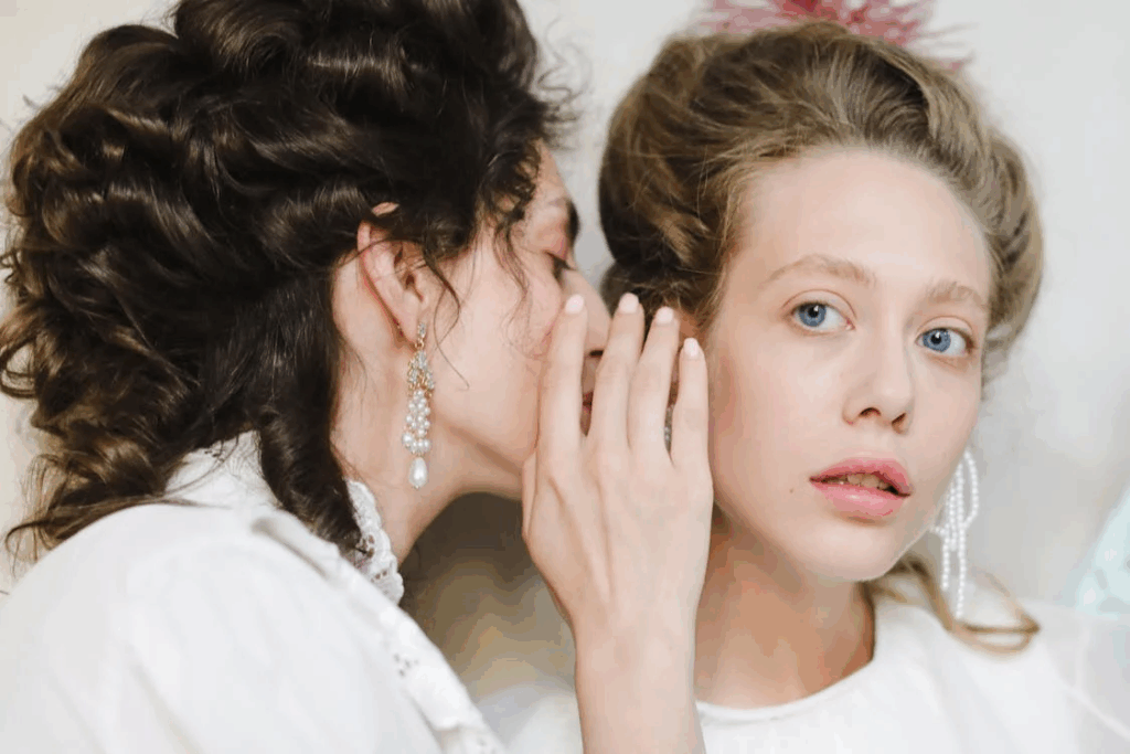 A Woman Whispering to the Ear of Another Woman