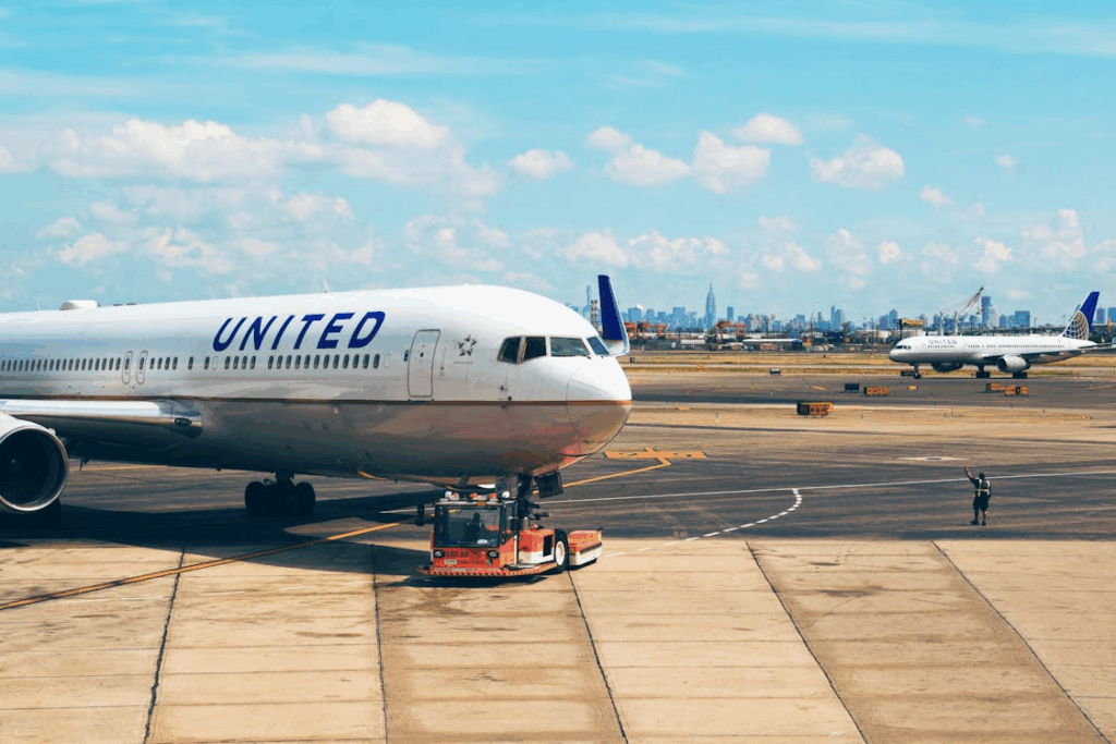 White Airplane Near Man in Green Vest