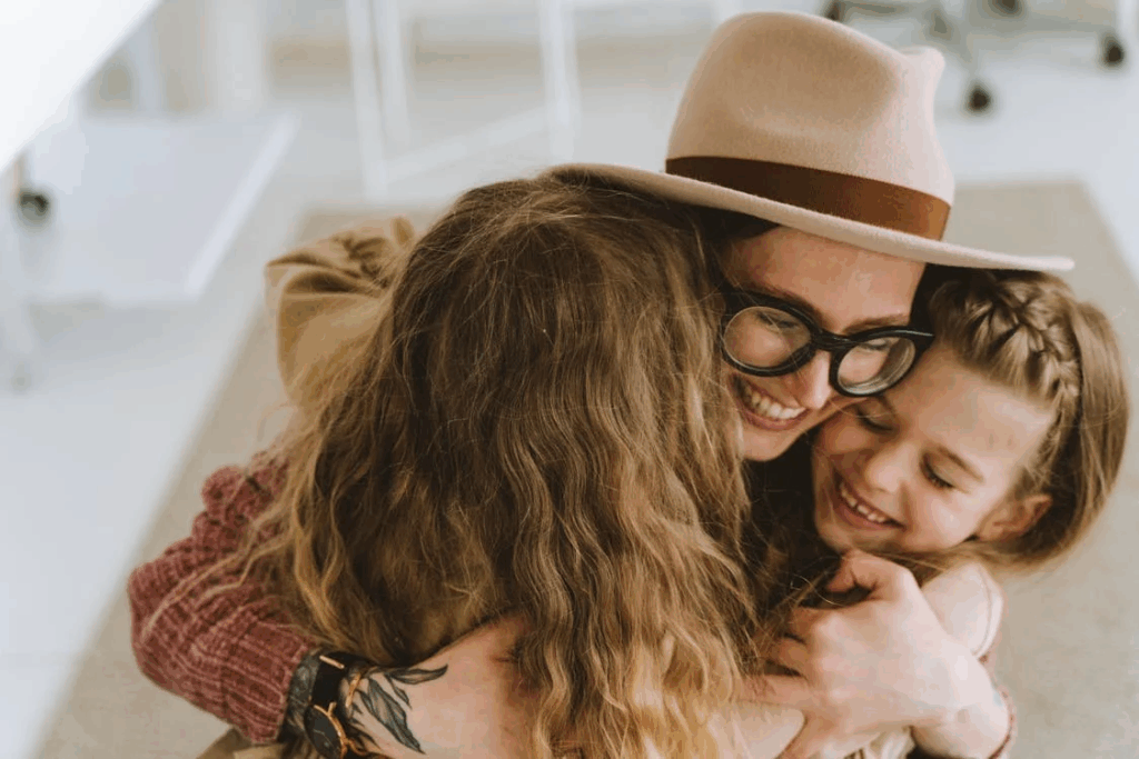 Woman Wearing a Hat Embracing Two Children