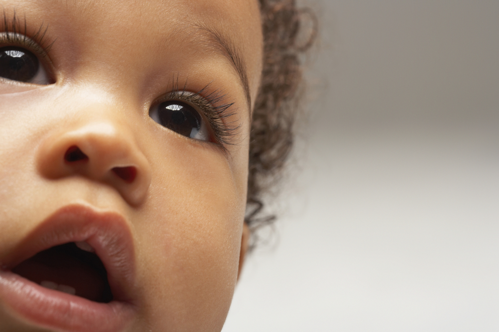 Closeup of African American curious baby boy looking away