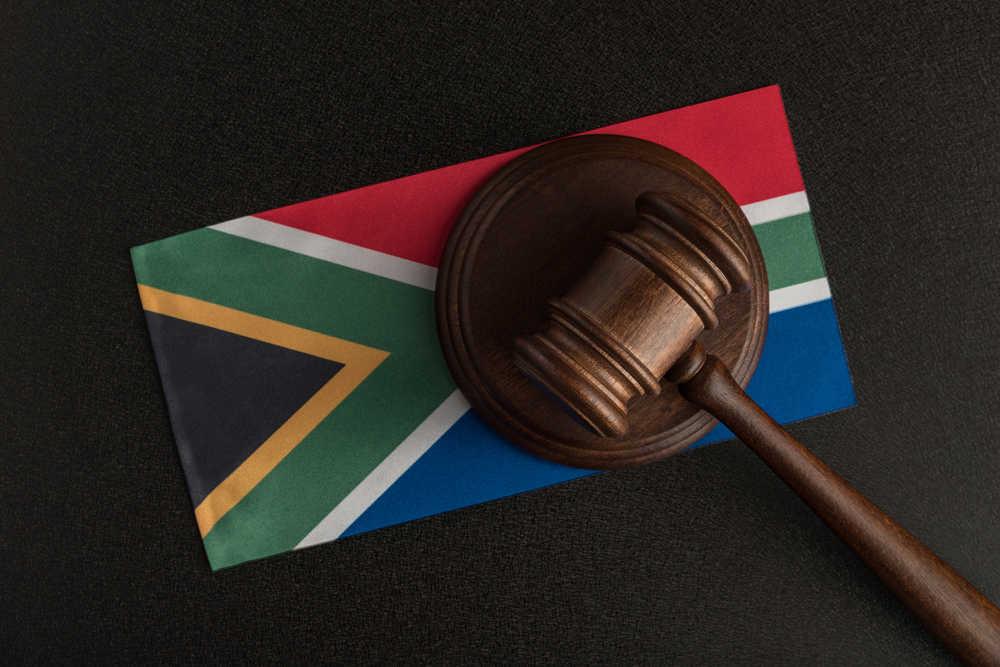 Judges hammer and flag of South Africa. Law of South Africa. Violation of rights.