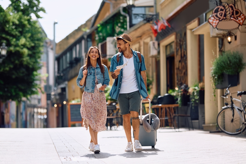 Happy couple of tourists walking in the city while traveling together. Copy space.