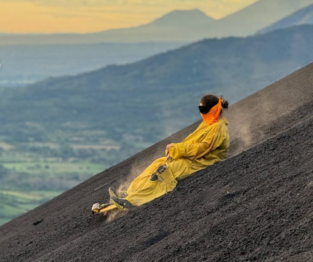 Person boarding down side of volcano