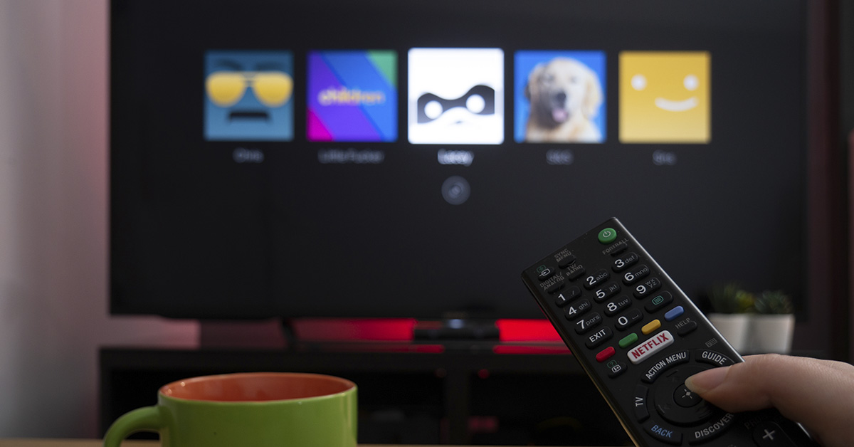 person using Netflix pointing remote at TV