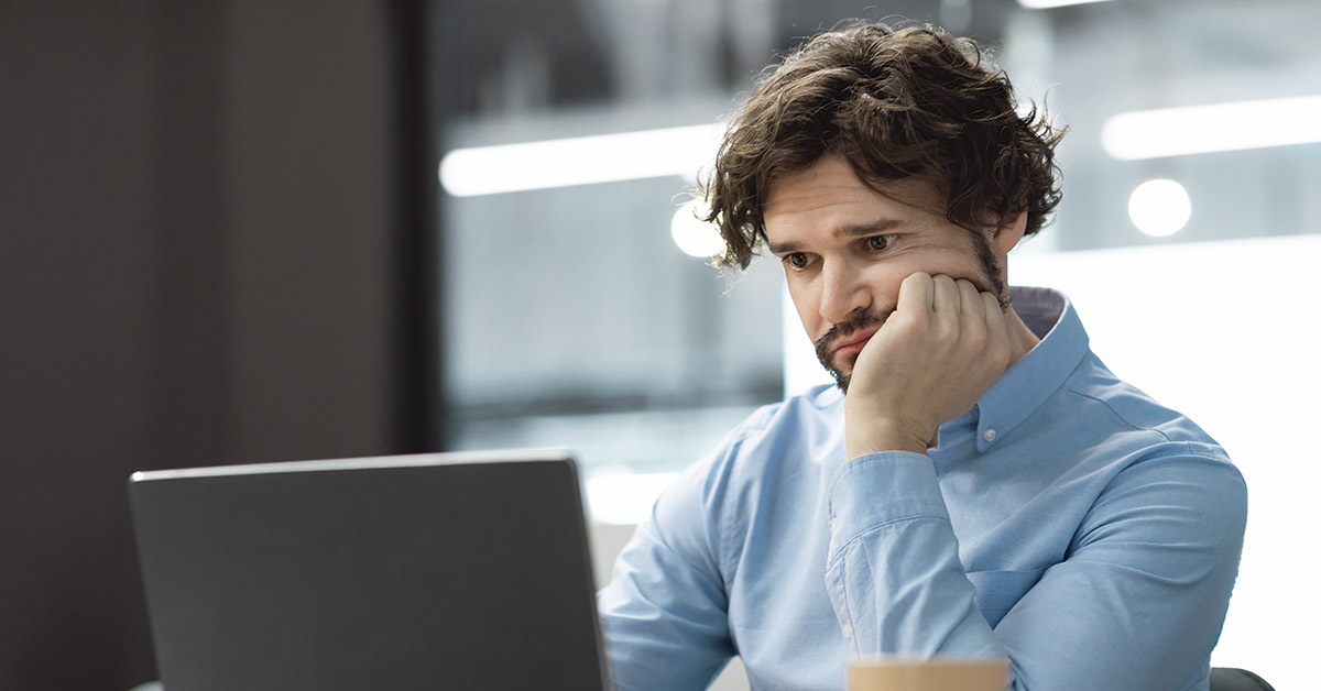 man, puzzled, looking at computer screen