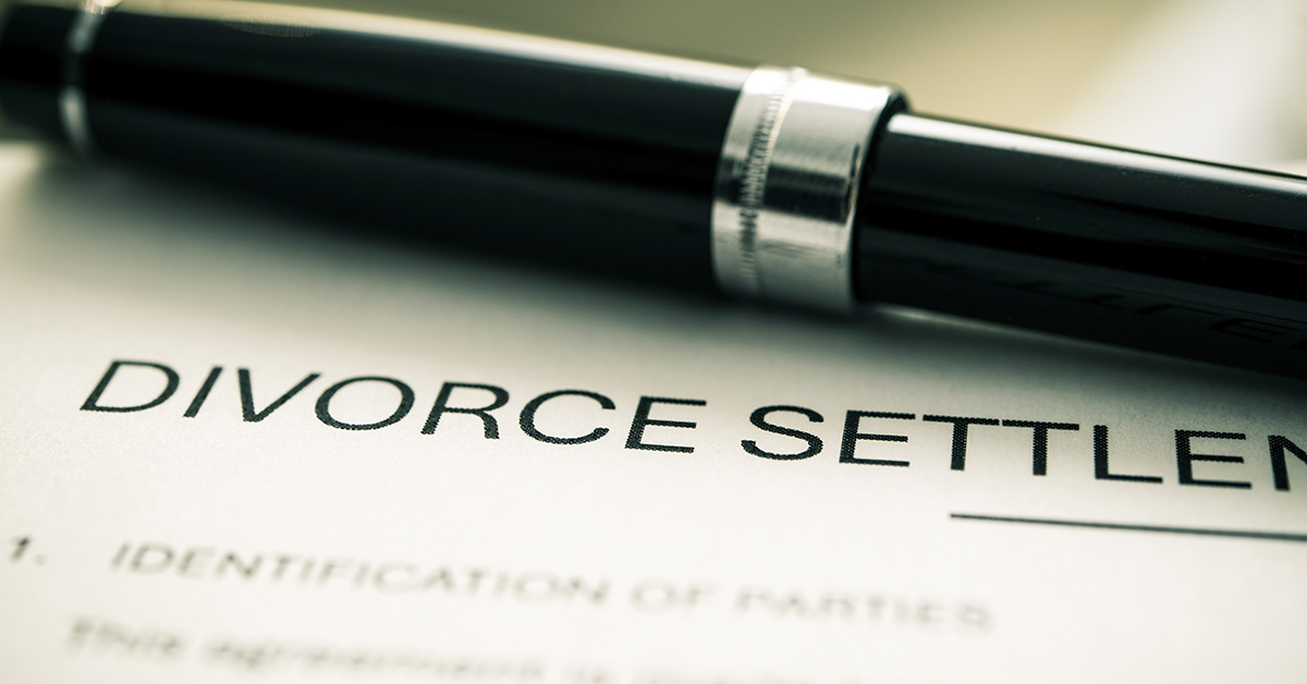 Divorce settlement document with a pen placed on top of it to sign