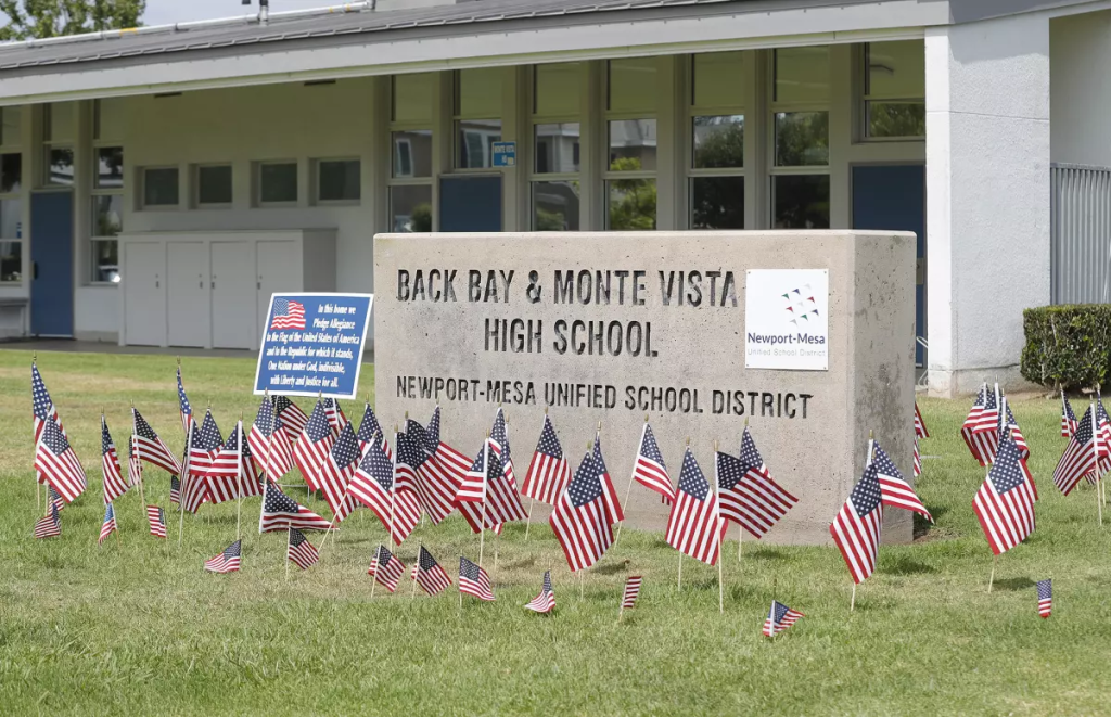 Small American flags are placed around the Back Bay and Monte Vista High School marquee sign