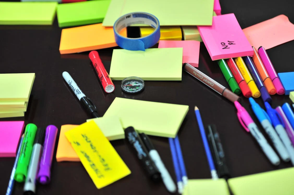 Sticky Notes and Colored Pens Scrambled on Table