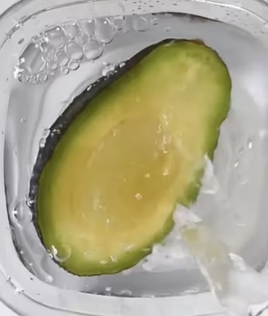 When the cut surface of the avocado is submerged in water, it limits its contact with oxygen