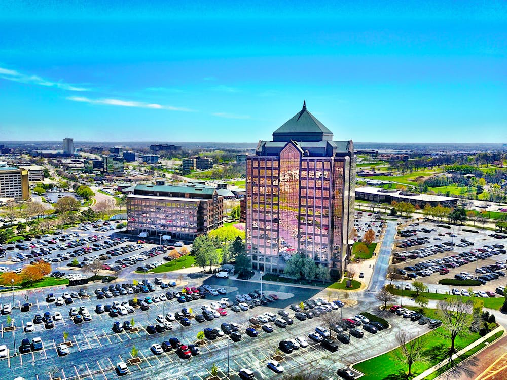 Aerial view of Overland Park's modern office towers and well-maintained public spaces surrounded by parking areas and green spaces, representing one of the happiest cities in the United States for suburban family living.