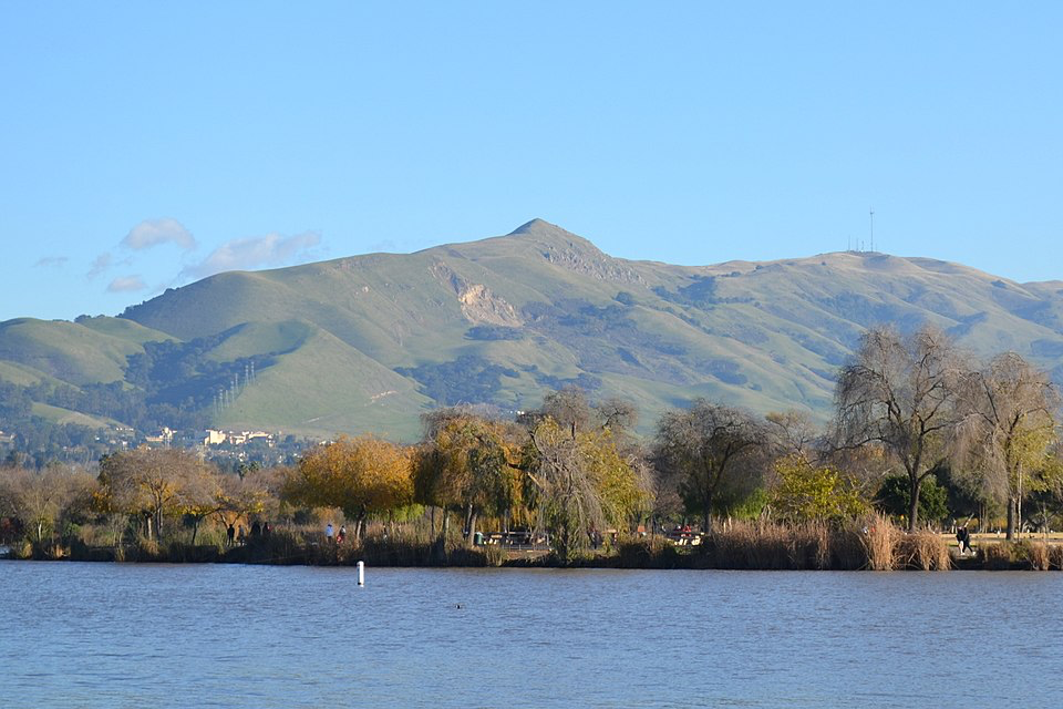 Fremont's serene lakeside setting with mountains and autumn trees, showcasing the natural beauty supporting America's happiest residents.