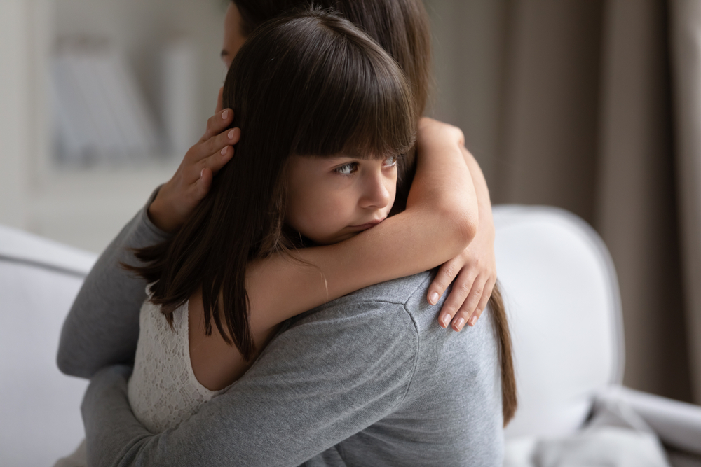 Close up view of upset little daughter cuddling mother, child receiving protection and support from mommy, adopted kid girl and new parent, sole custody, offspring and motherhood connection concept